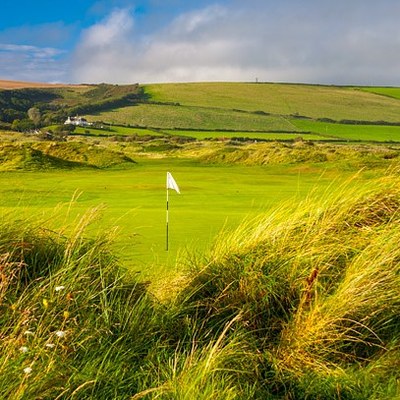 Saunton Sands Golf Club clubhouse and bunkers beside the putting surface